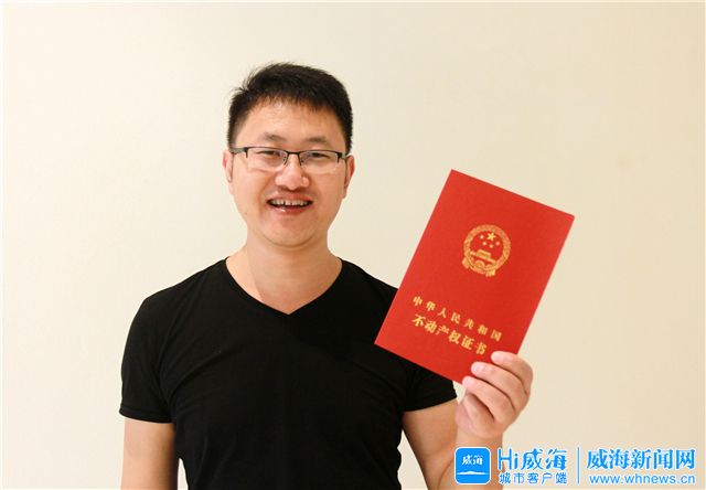 生活在神道口生活小区的曹轩铭高兴地展示办好的房产证.